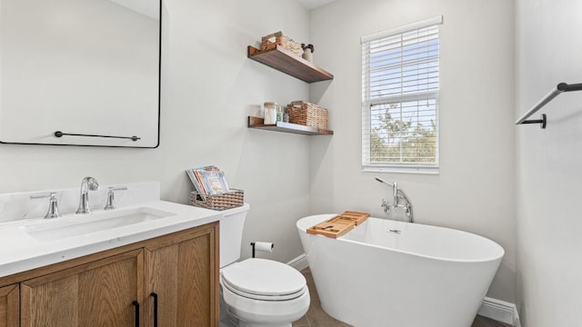 bathroom with a bathtub, vanity, toilet, and plenty of natural light