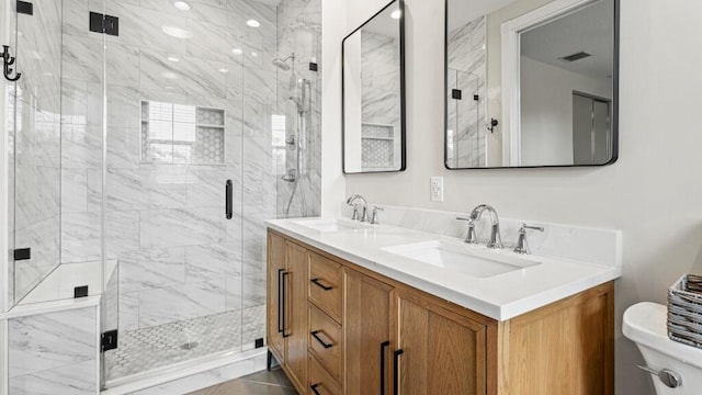 bathroom with walk in shower, vanity, and toilet