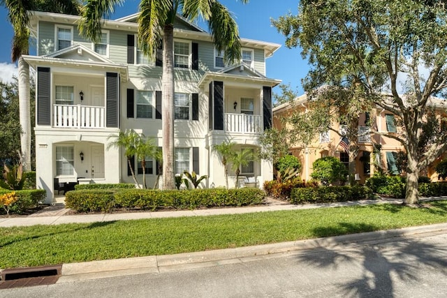 view of front facade featuring a balcony and a front yard