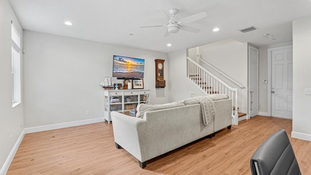 living room with light hardwood / wood-style floors and ceiling fan