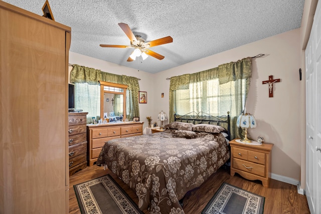 bedroom with a textured ceiling, hardwood / wood-style flooring, ceiling fan, and a closet