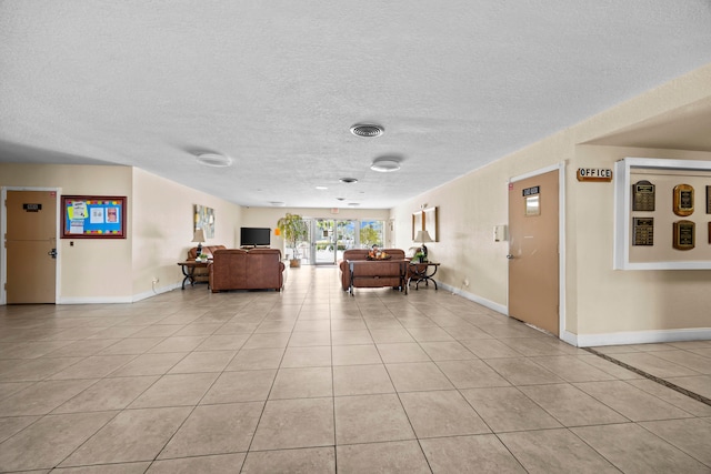 living room with a textured ceiling and light tile patterned floors