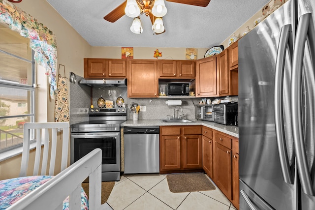 kitchen featuring a textured ceiling, stainless steel appliances, sink, and tasteful backsplash