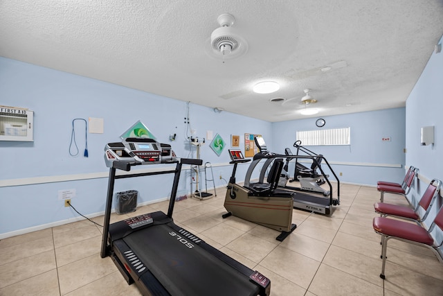 exercise room with light tile patterned flooring, a textured ceiling, and ceiling fan