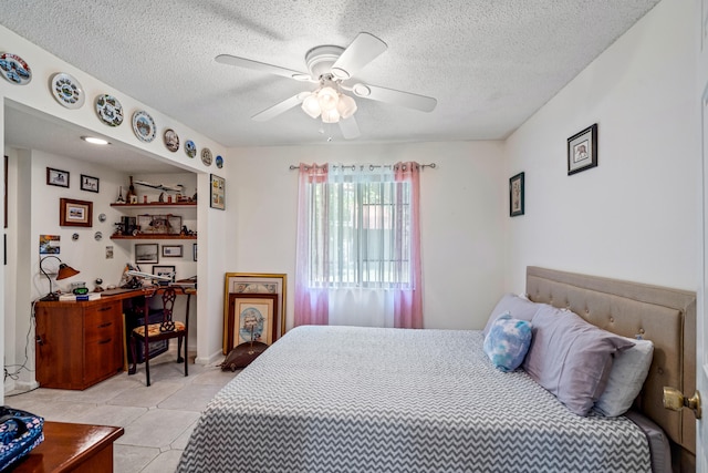 bedroom featuring a textured ceiling, ceiling fan, and light tile patterned floors