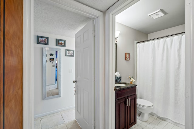 bathroom with vanity, tile patterned flooring, toilet, and a textured ceiling