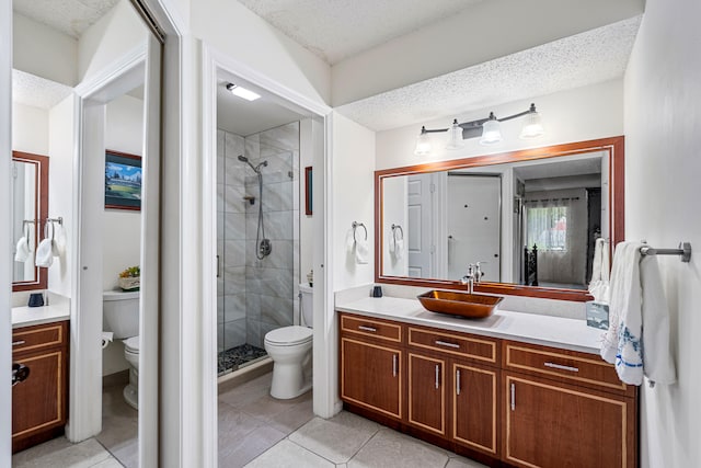 bathroom with toilet, vanity, tile patterned floors, and a shower with door