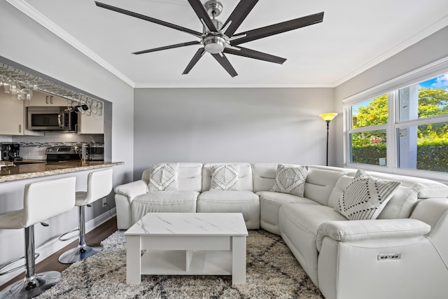 living room featuring hardwood / wood-style floors, ceiling fan, and crown molding