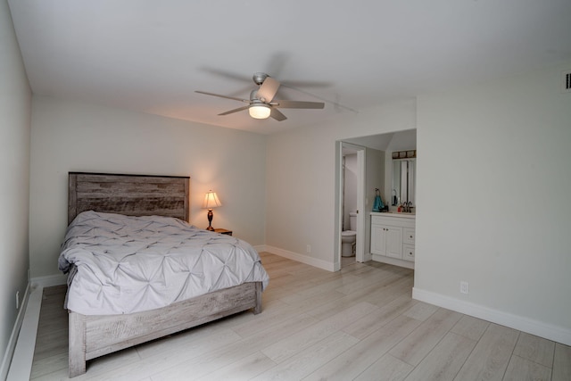 bedroom with light hardwood / wood-style flooring, ceiling fan, and connected bathroom