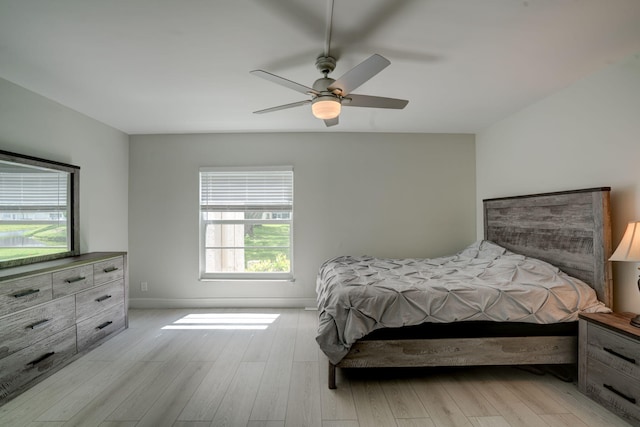 bedroom featuring multiple windows, ceiling fan, and light hardwood / wood-style flooring