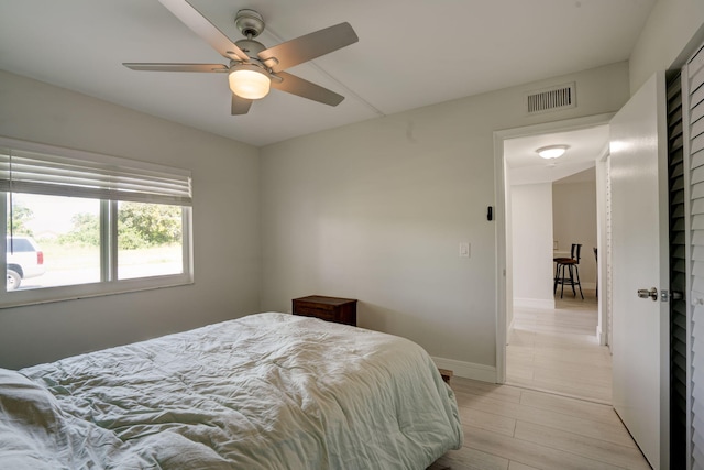 bedroom with light wood-type flooring and ceiling fan