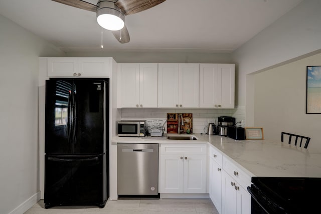 kitchen featuring black appliances, sink, light stone counters, and white cabinets