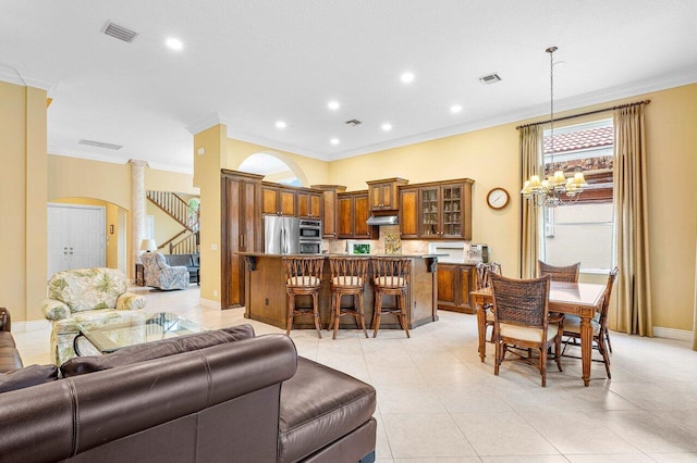 tiled living room featuring a chandelier and ornamental molding