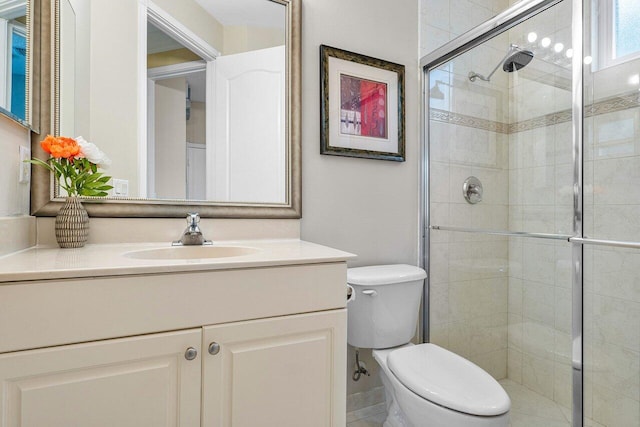 bathroom with vanity, toilet, and a shower with shower door