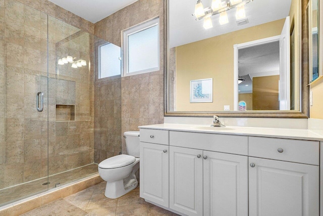 bathroom with tile patterned floors, vanity, toilet, and a shower with door