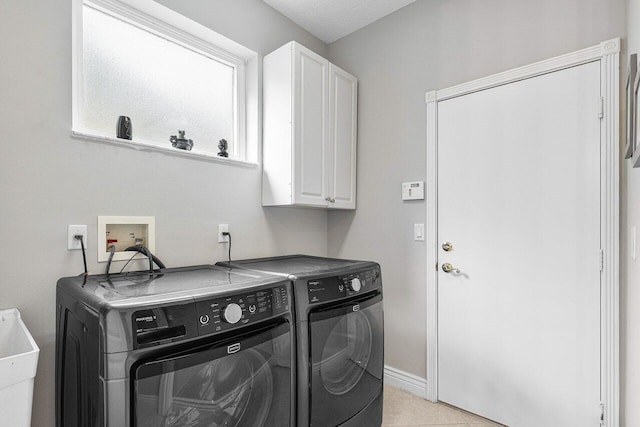 laundry area with cabinets, a textured ceiling, sink, light tile patterned floors, and separate washer and dryer