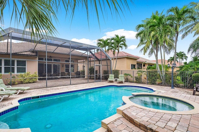 view of pool featuring glass enclosure and an in ground hot tub