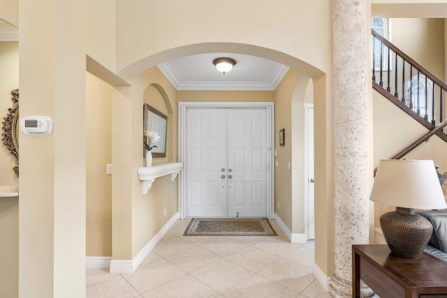 tiled foyer entrance with crown molding