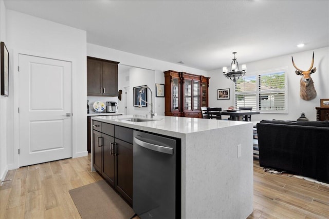 kitchen featuring a center island with sink, sink, light hardwood / wood-style floors, dishwasher, and a chandelier