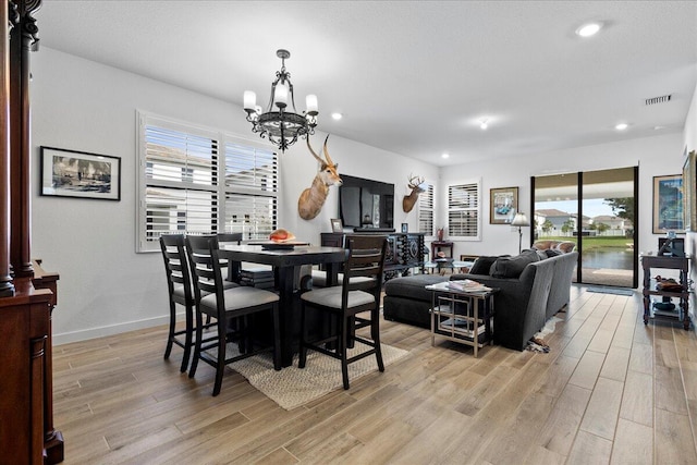 dining room featuring an inviting chandelier, plenty of natural light, and light hardwood / wood-style flooring