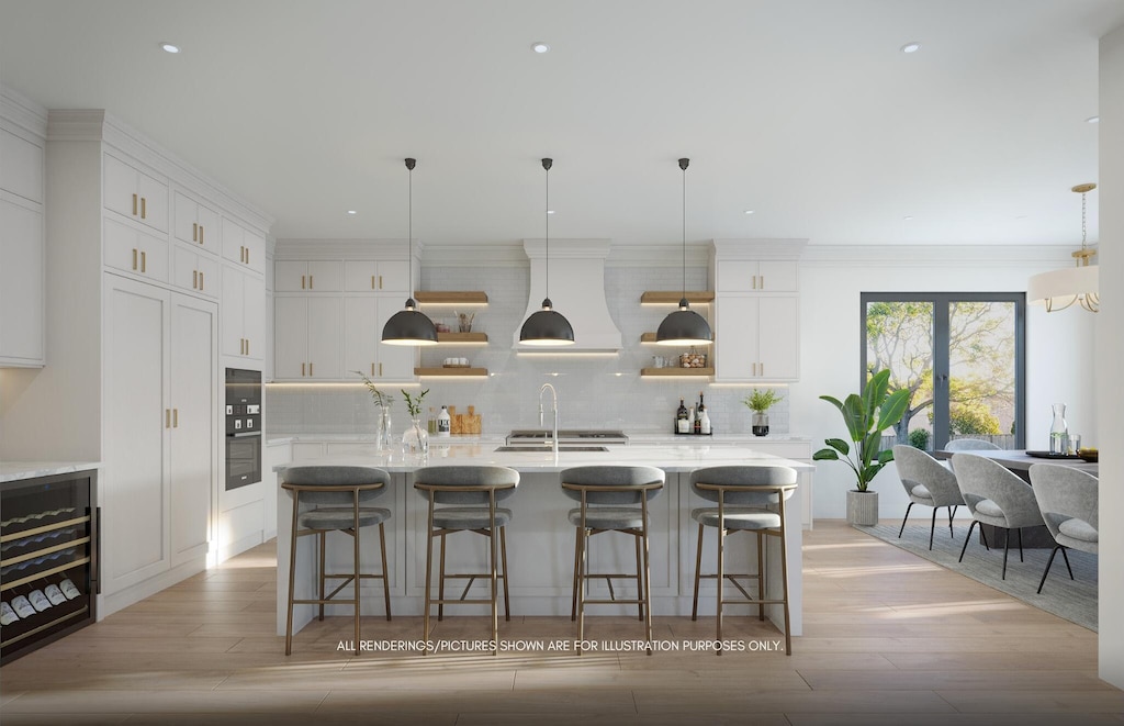 kitchen with a large island, a breakfast bar area, custom range hood, white cabinets, and decorative light fixtures