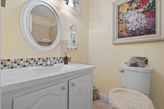 bathroom featuring vanity, toilet, and decorative backsplash