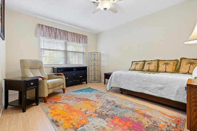 bedroom with light hardwood / wood-style flooring and ceiling fan