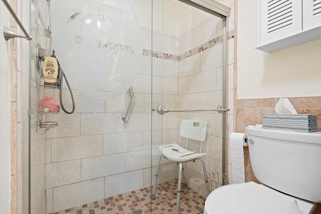 bathroom featuring toilet, an enclosed shower, and tile walls