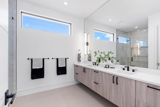 bathroom featuring a wealth of natural light, vanity, and a shower with shower door