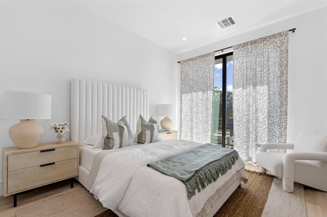 bedroom with hardwood / wood-style flooring and access to exterior