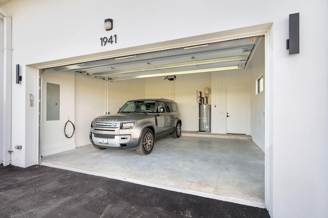 garage featuring electric panel, a garage door opener, and water heater