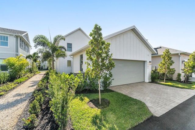 7751 SW Ann St, Palm City, FL 34990 - view of front of home featuring a garage, driveway, and board and batten siding