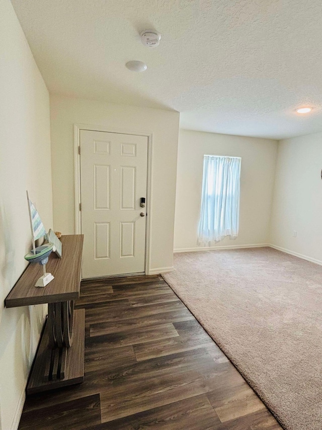 entryway featuring a textured ceiling and dark wood-type flooring