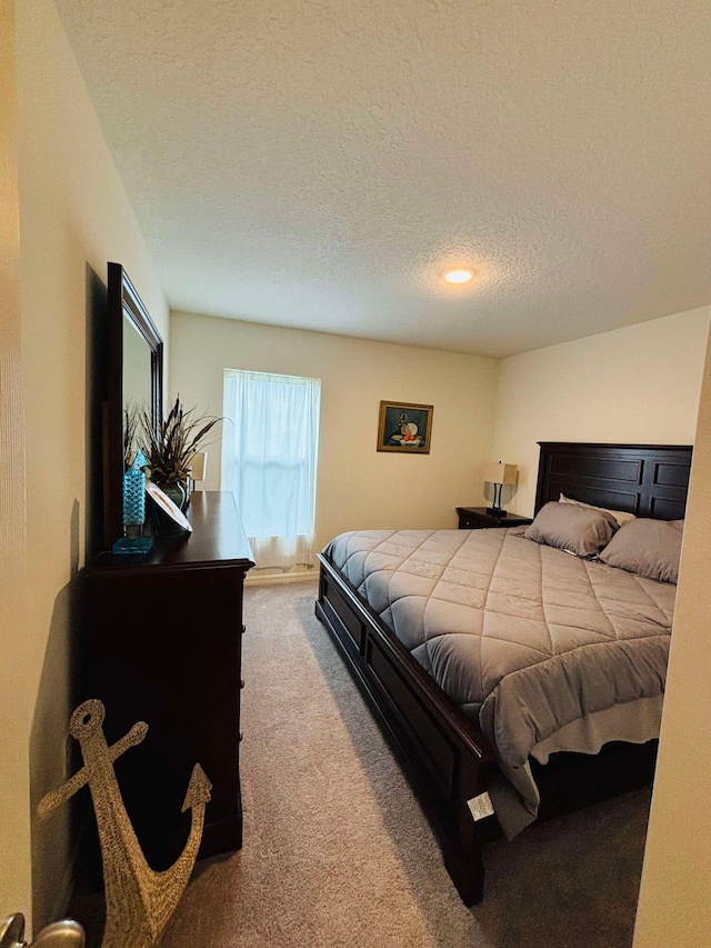 bedroom with carpet and a textured ceiling