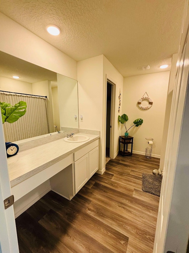 bathroom featuring vanity, hardwood / wood-style floors, and a textured ceiling