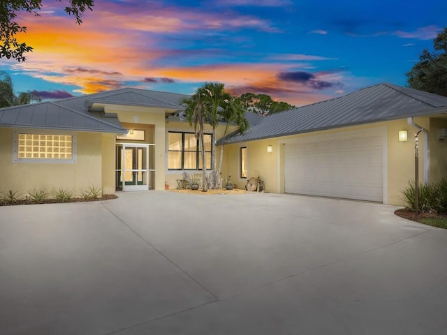 prairie-style house featuring a garage and french doors