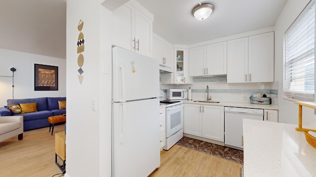 kitchen featuring white cabinetry, light hardwood / wood-style flooring, sink, and white appliances