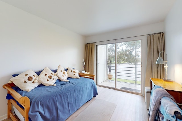 bedroom with access to exterior and light hardwood / wood-style floors