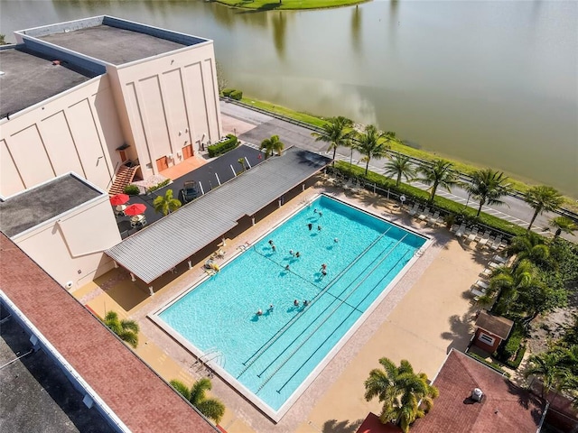 view of swimming pool with a water view and a patio area