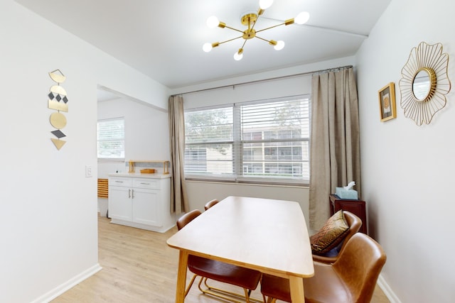 dining area with a notable chandelier and light hardwood / wood-style floors