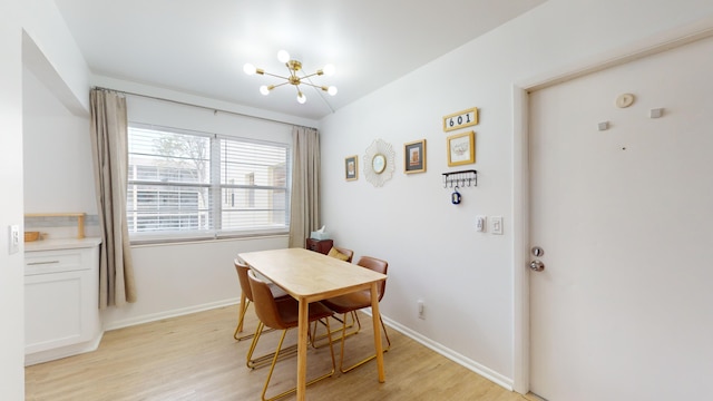 dining room with light wood-type flooring and a notable chandelier