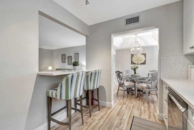 dining room with a chandelier and light wood-type flooring