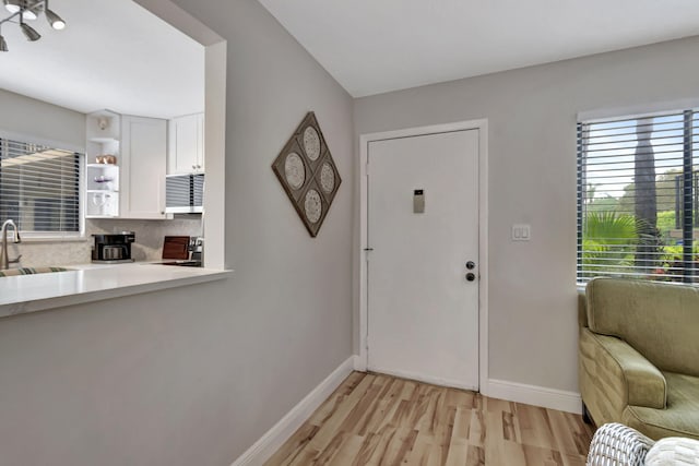 foyer entrance with light hardwood / wood-style flooring and sink