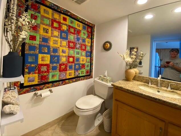 bathroom with tile patterned flooring, vanity, and toilet