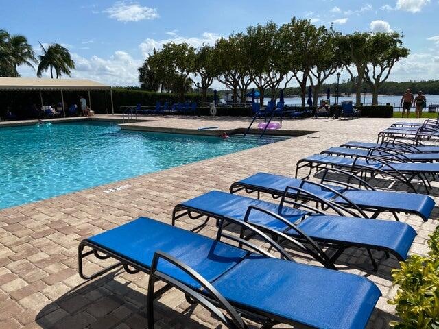 view of swimming pool featuring a patio and a water view