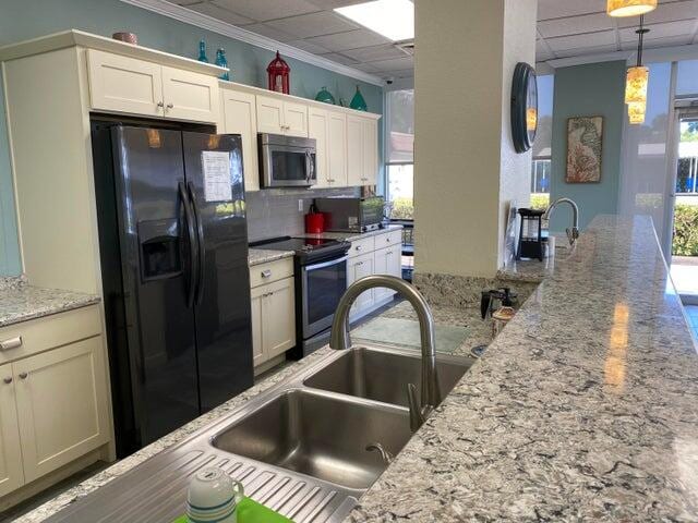 kitchen featuring appliances with stainless steel finishes, a healthy amount of sunlight, and light stone counters