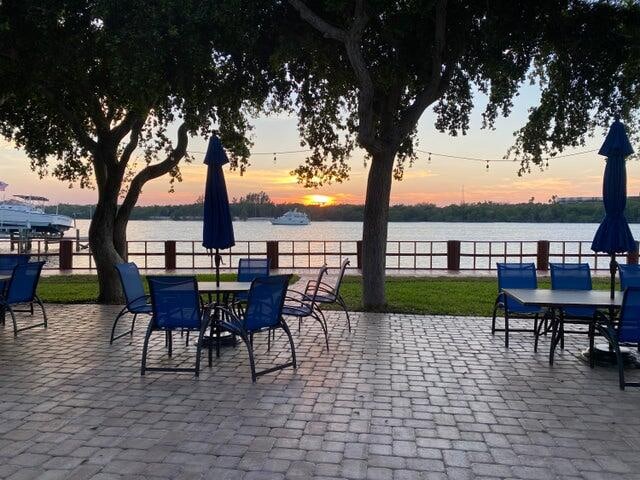 patio terrace at dusk featuring a water view