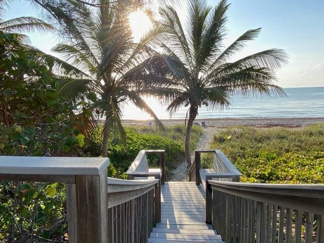 surrounding community featuring a water view and a beach view