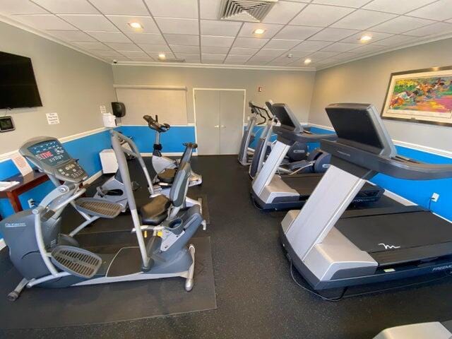 exercise room featuring crown molding and a drop ceiling