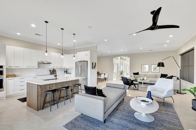 tiled living room featuring ceiling fan and ornamental molding